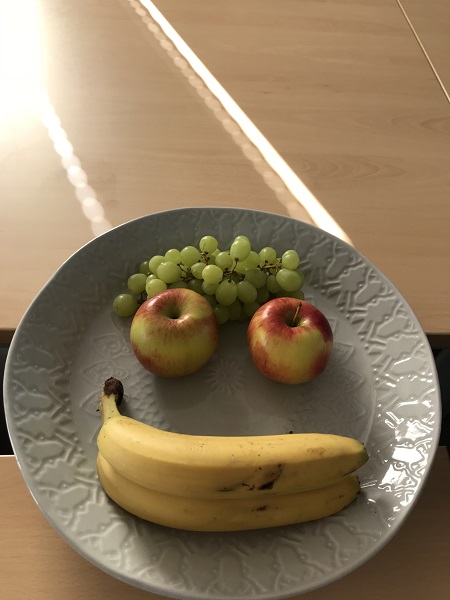 Obst garniert als Smiley (Trauben als Haare, Äpfel als Augen & Bananen als Munnd)